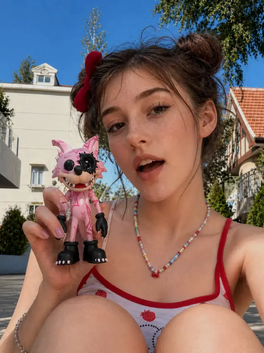 Creator carrying a smooth hard-shell WOWNNY collectible on a patio
